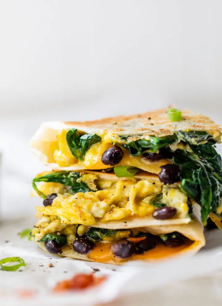 egg and black bean quesadilla stacked on parchment paper