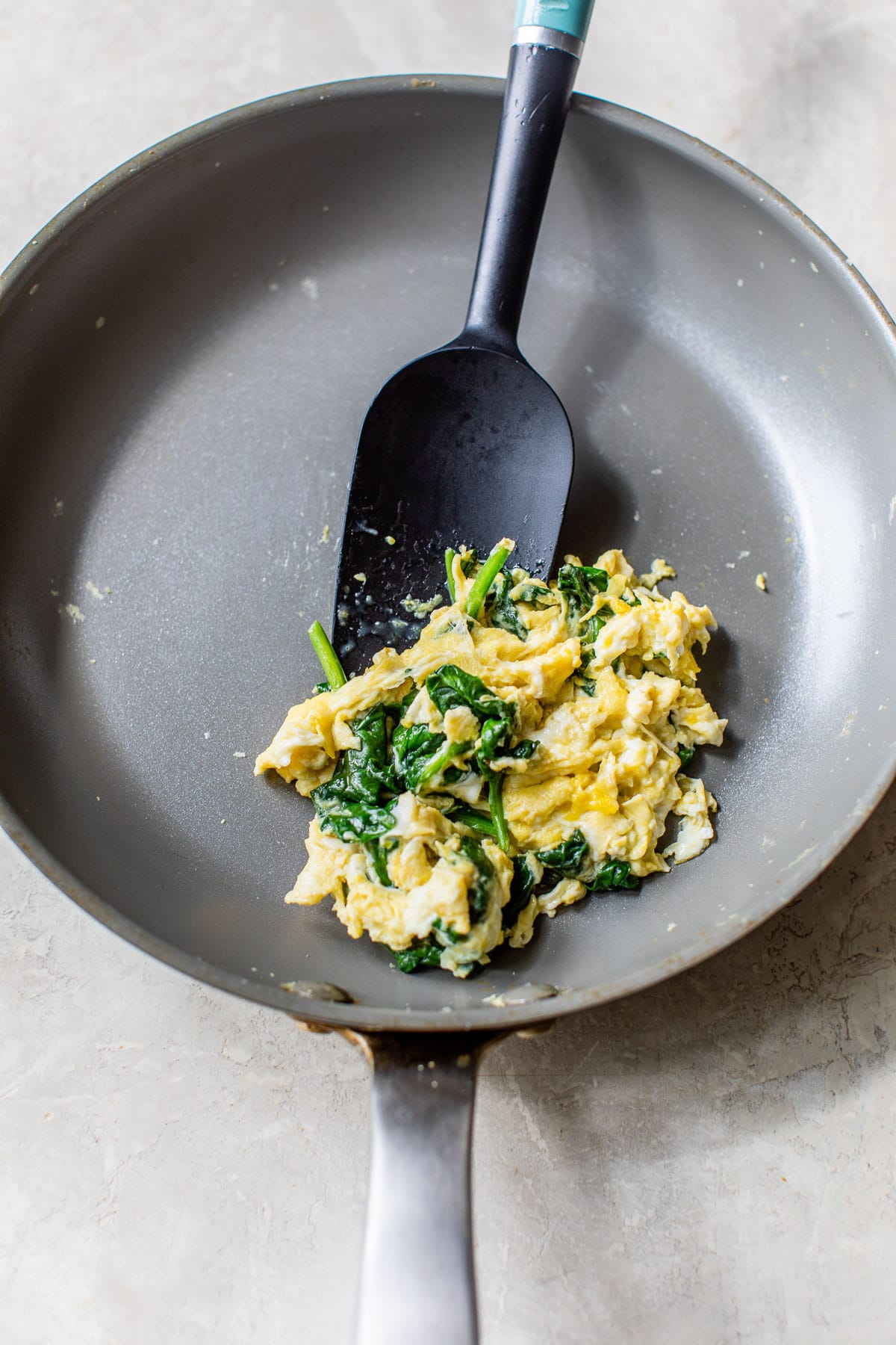 scrambled eggs and spinach in a skillet