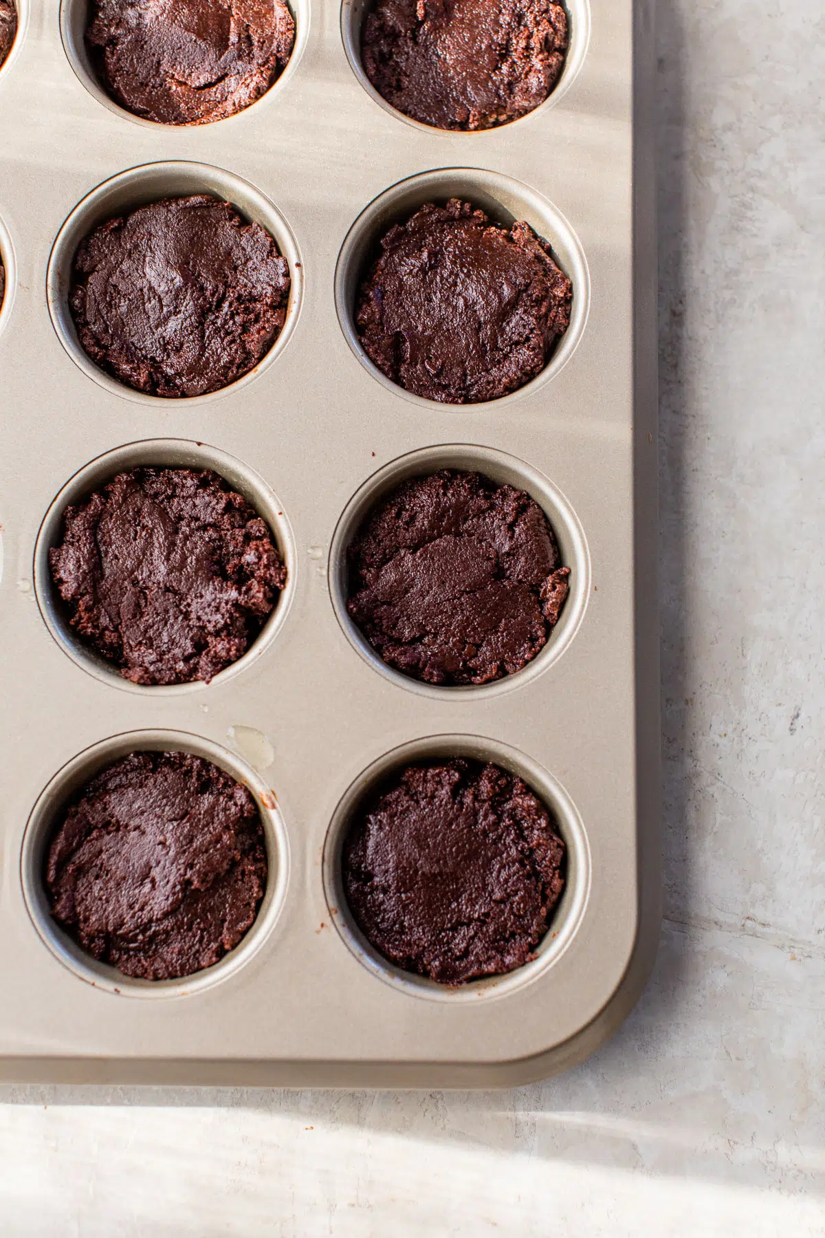 brownie batter in a muffin tin