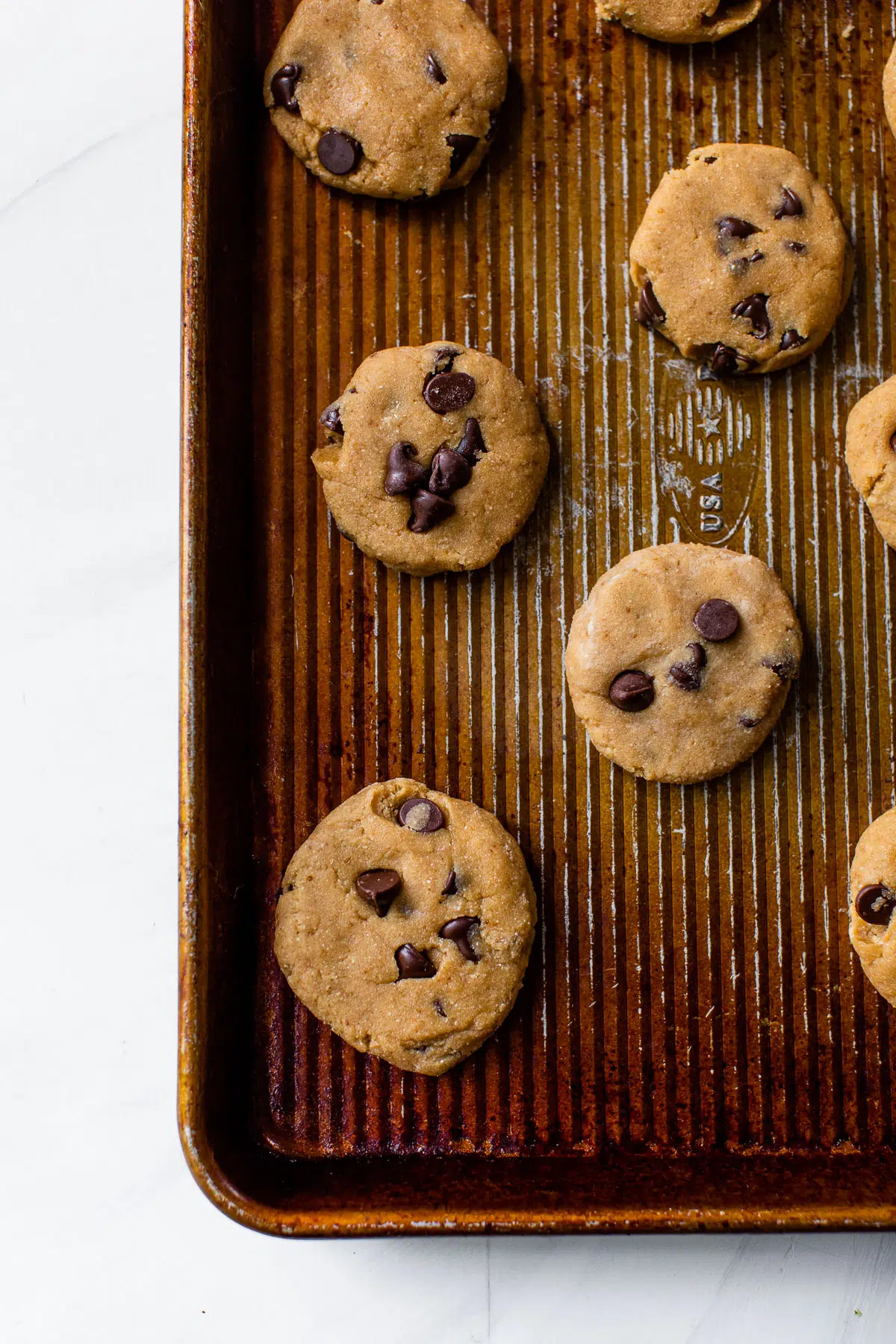 unbaked cookies with chocolate chips on a baking sheet