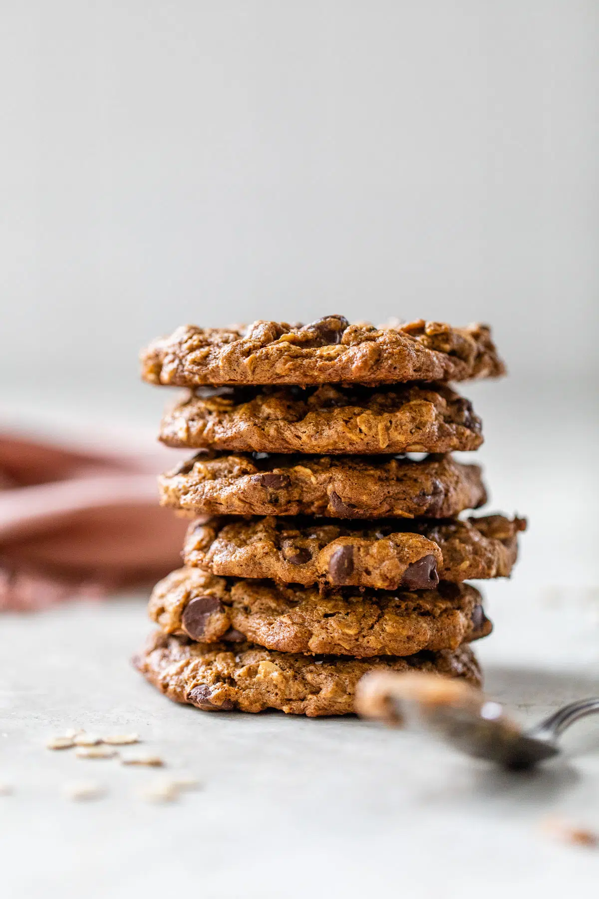 a stack of cookies beside a spoon of almond butter