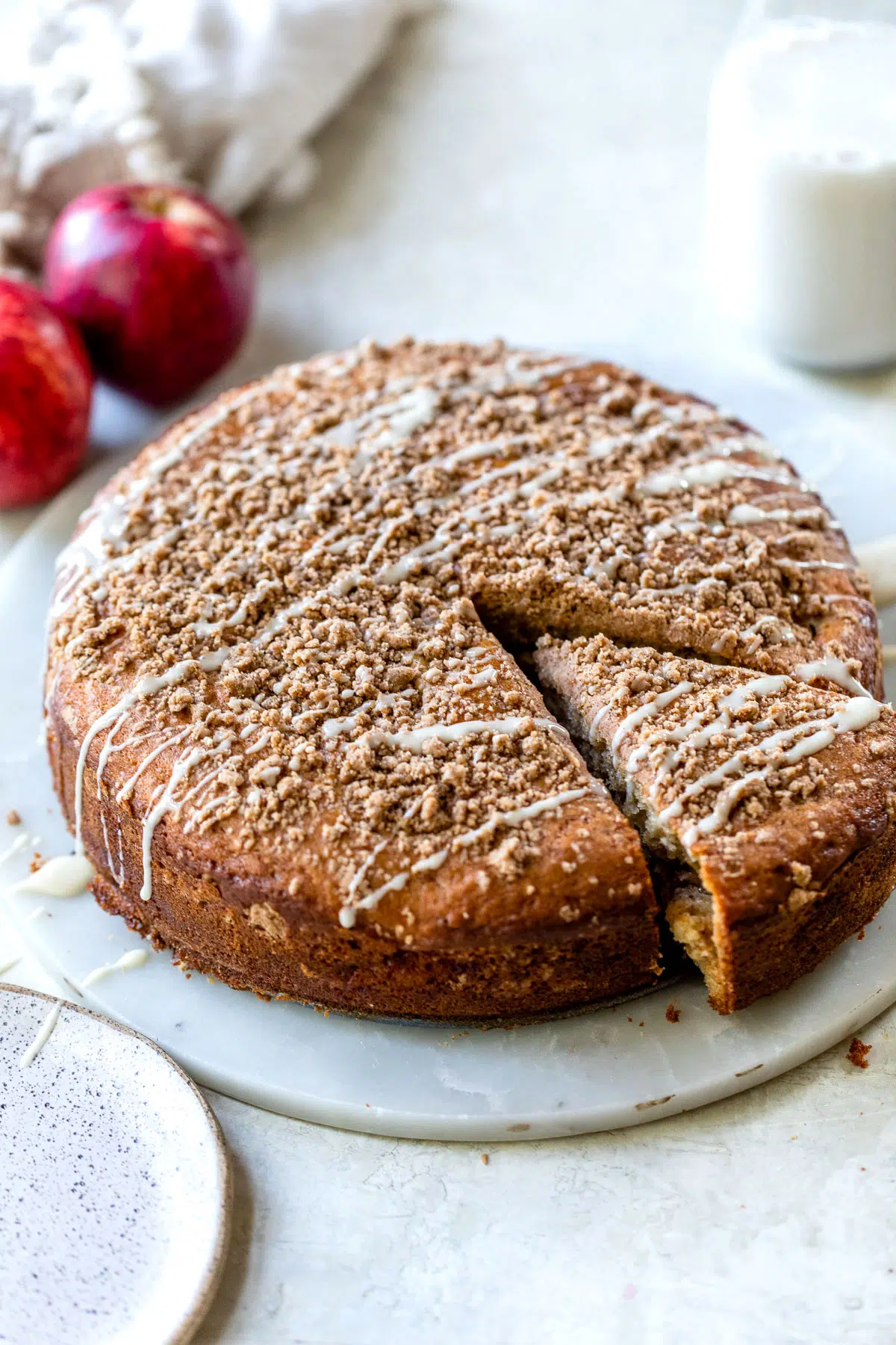 round coffee cake with a crumb topping on a round marble platter