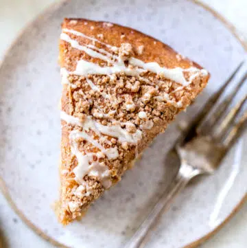 a piece of coffee cake on a plate beside a fork