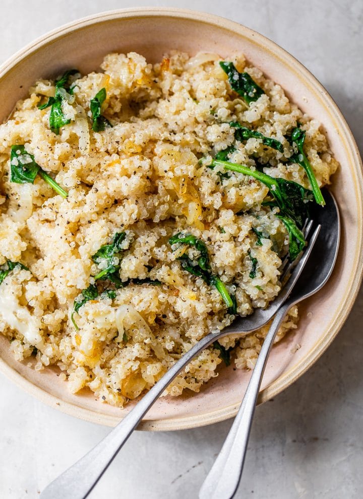 quinoa, onions and spinach in a pink bowl