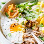 an over easy egg with runny yolk over pulled pork