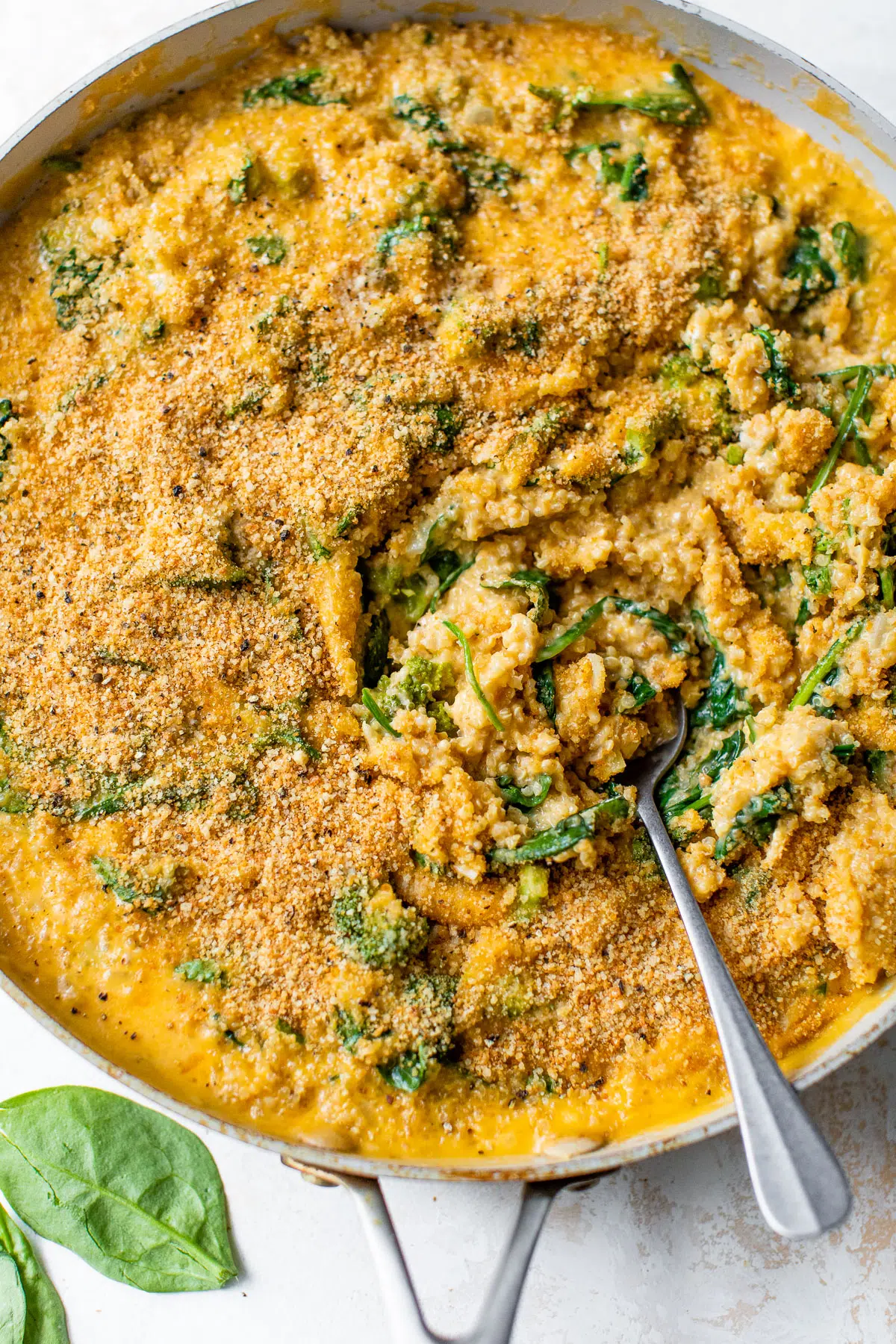mac and cheese with quinoa and spinach in a skillet