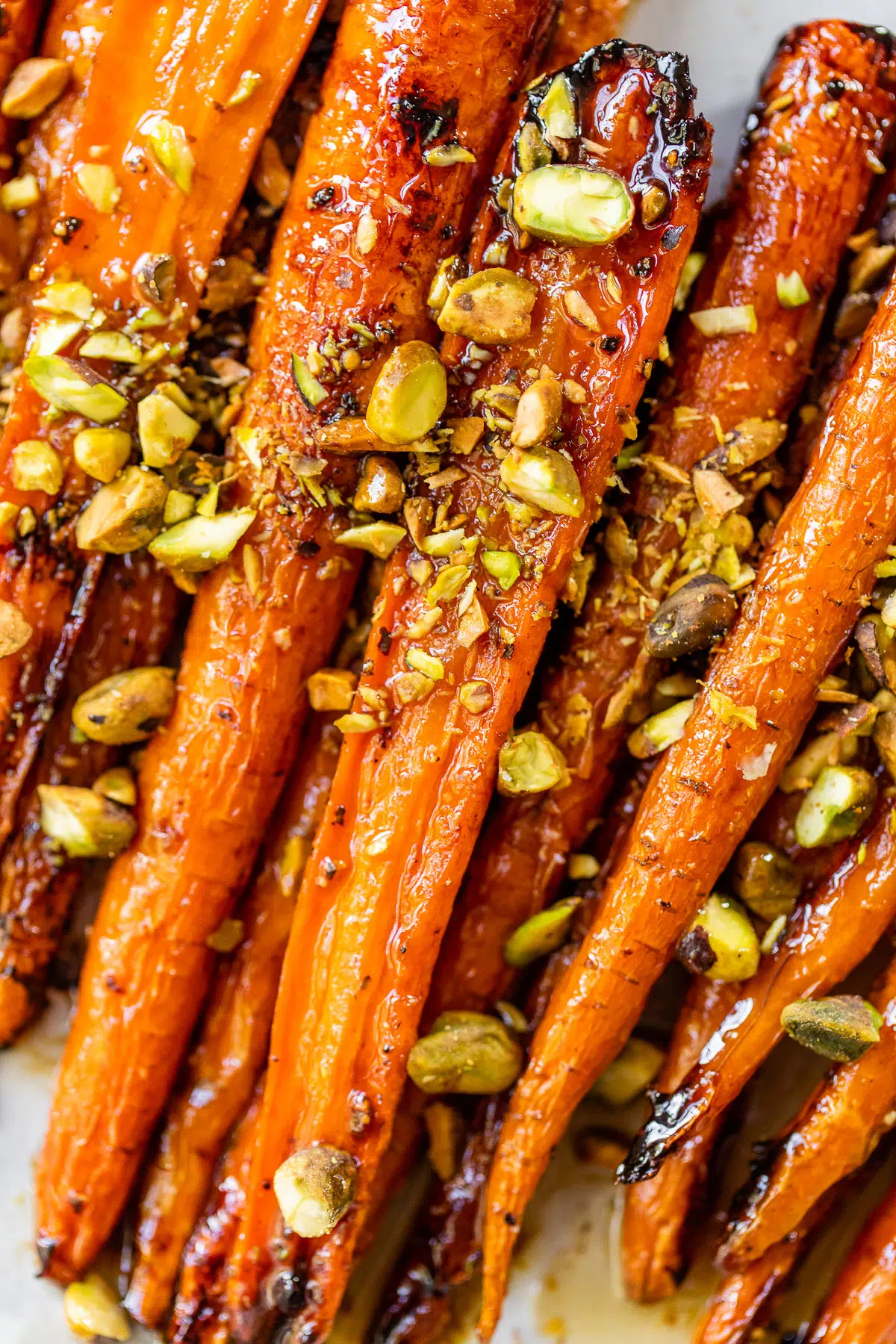 close up photo of carrots topped with pistachios