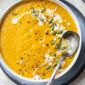 a bowl of blended soup topped with pumpkin seeds