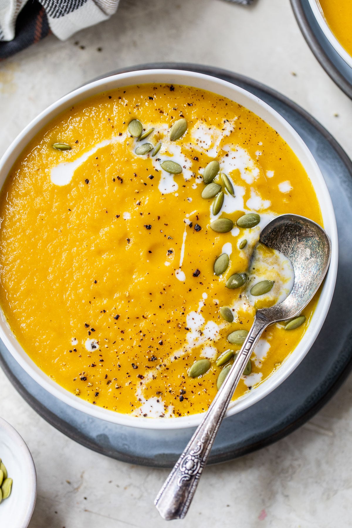 a bowl of blended soup topped with pumpkin seeds