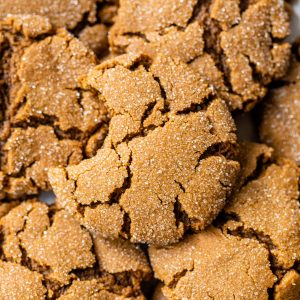 a pile of ginger cookies with a bite taken out of one cookie