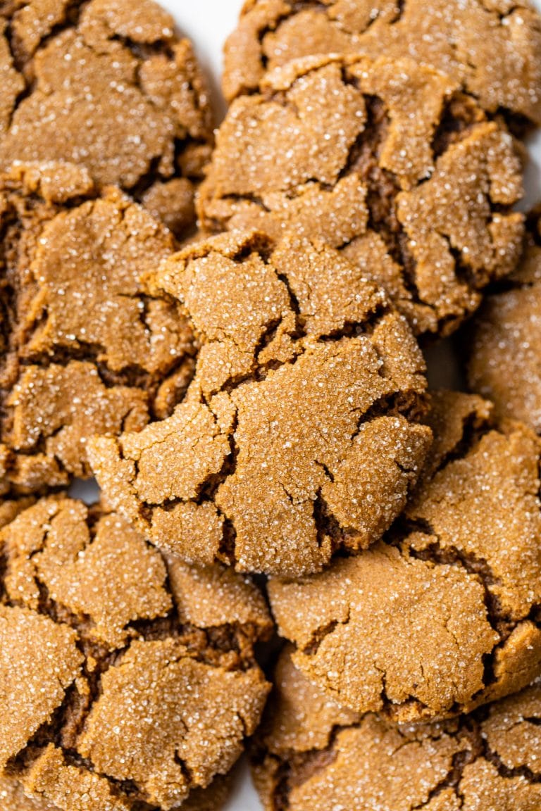 a pile of ginger cookies with a bite taken out of one cookie