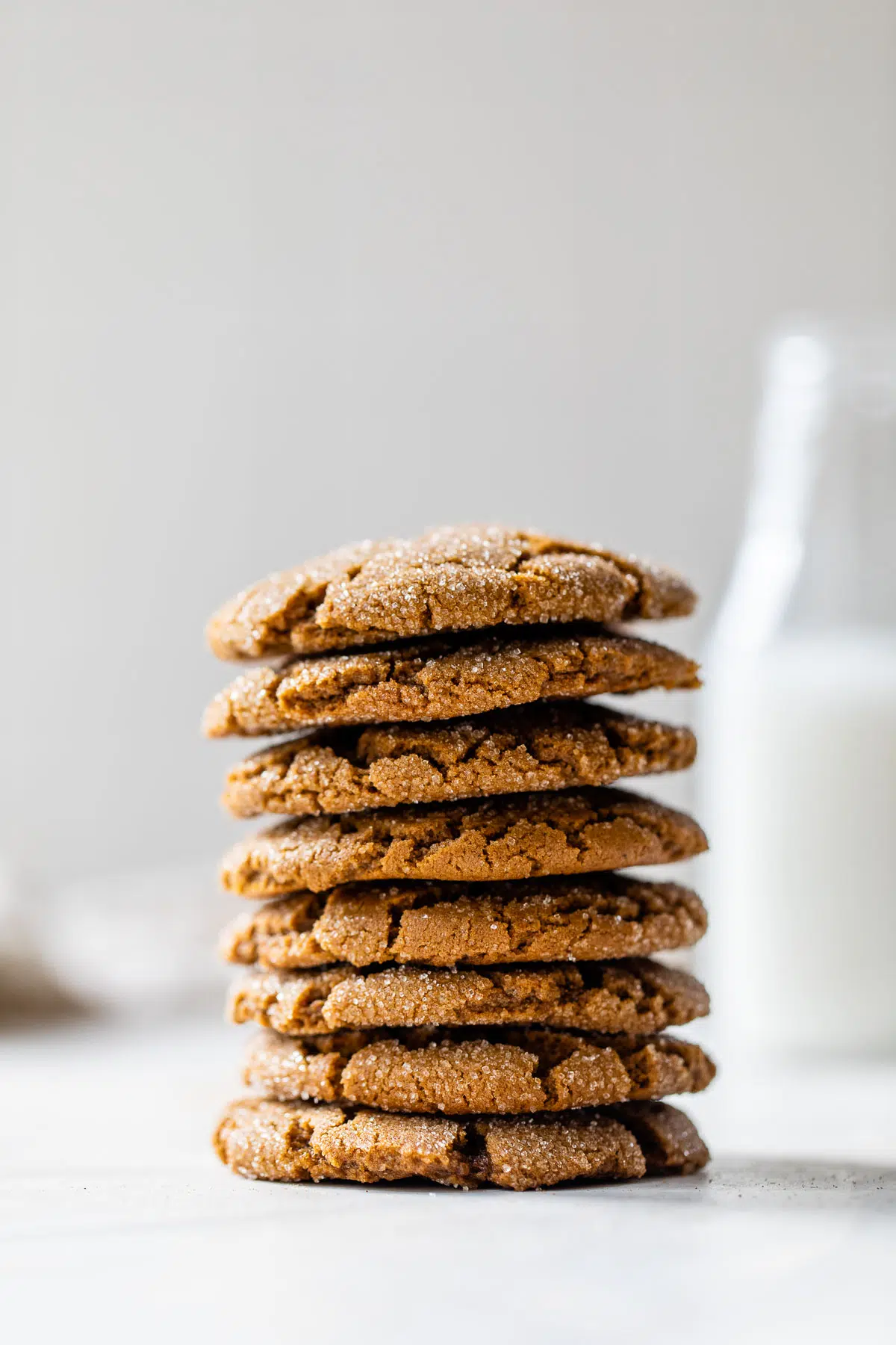 a stack of cookies beside a tall glass of milk