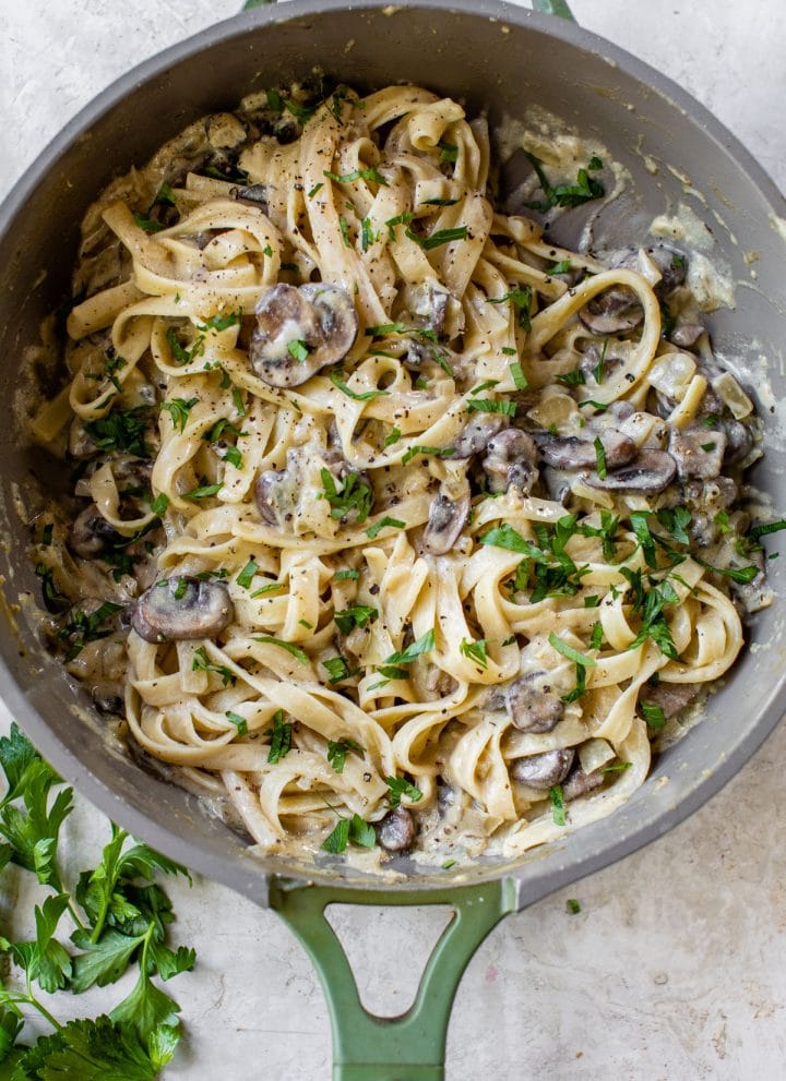pasta tossed in mushroom sauce in a skillet