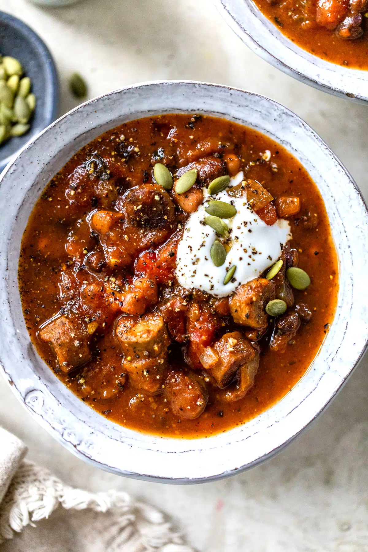 close up photo of a bowl of chili with beans and sausage