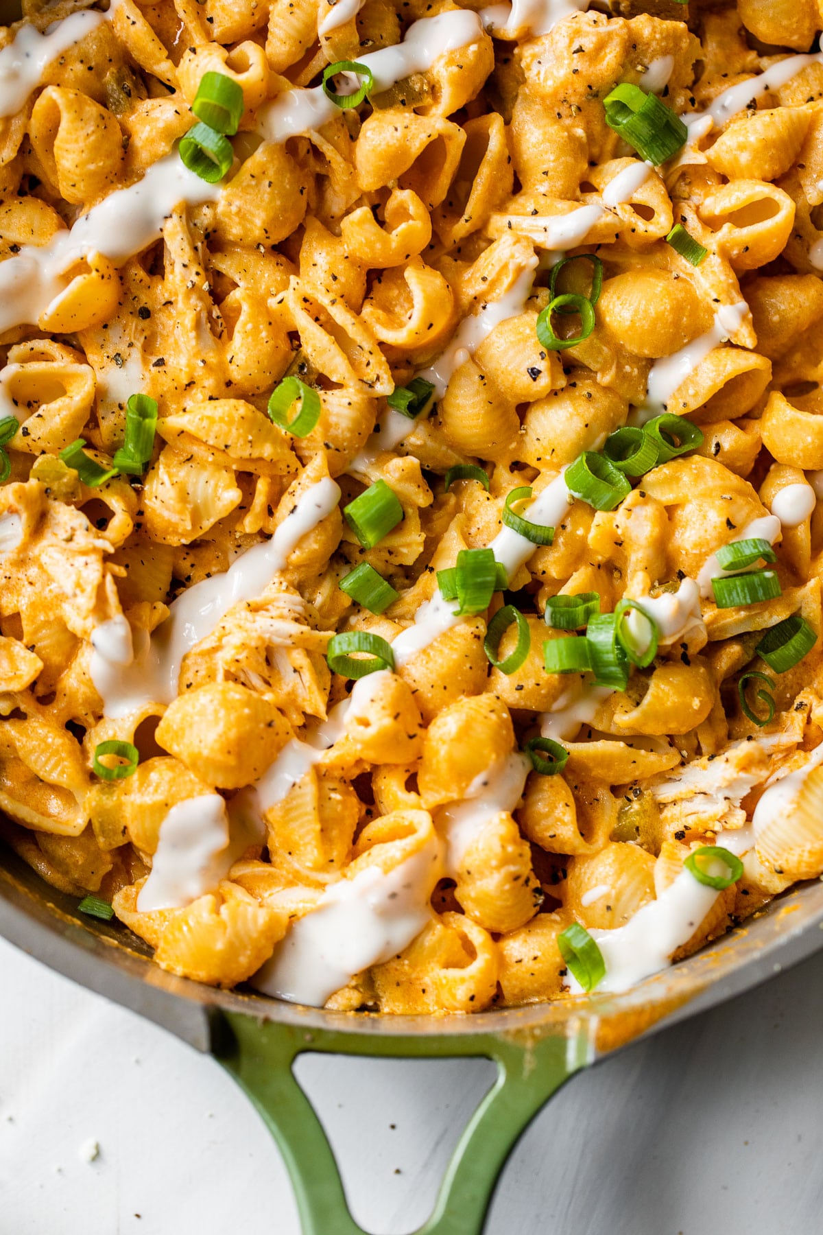 pasta and chicken in a skillet drizzled with ranch