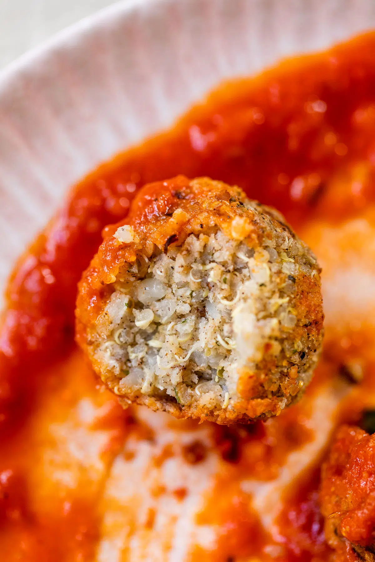 close up photo of a quinoa meatball with a bite taken out of it