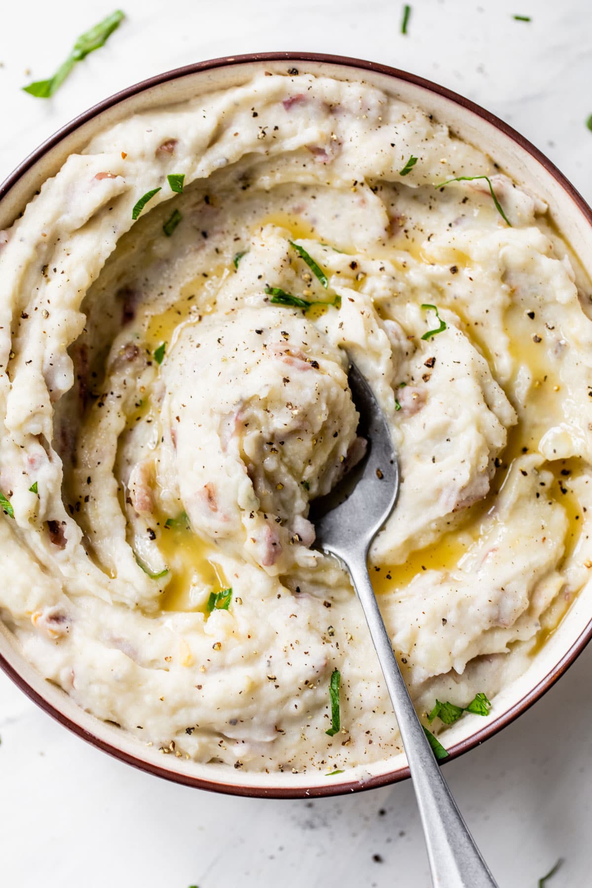 mashed potatoes in a bowl topped with melted butter