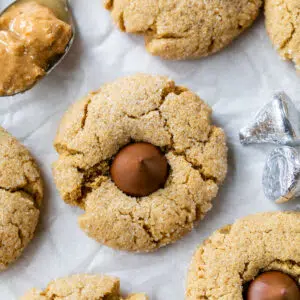 peanut butter cookies with hershey kisses in the middle on parchment paper