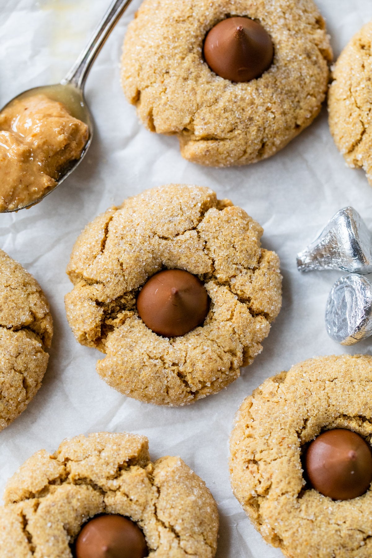 peanut butter cookies with hershey kisses in the middle on parchment paper