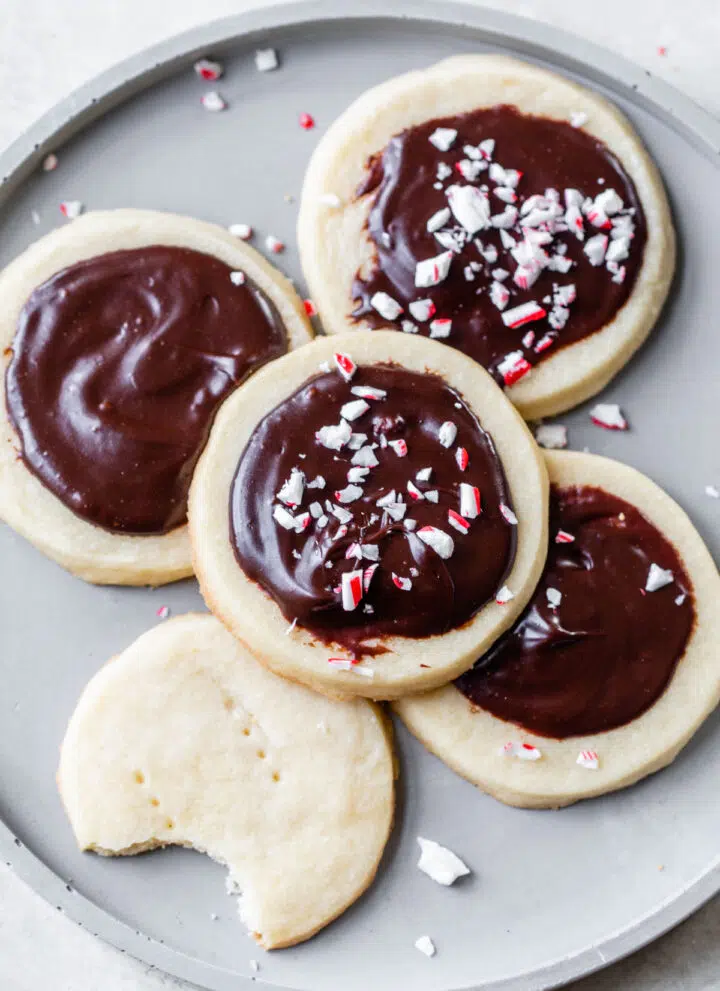 five shortbread cookies with chocolate icing on a gray plate