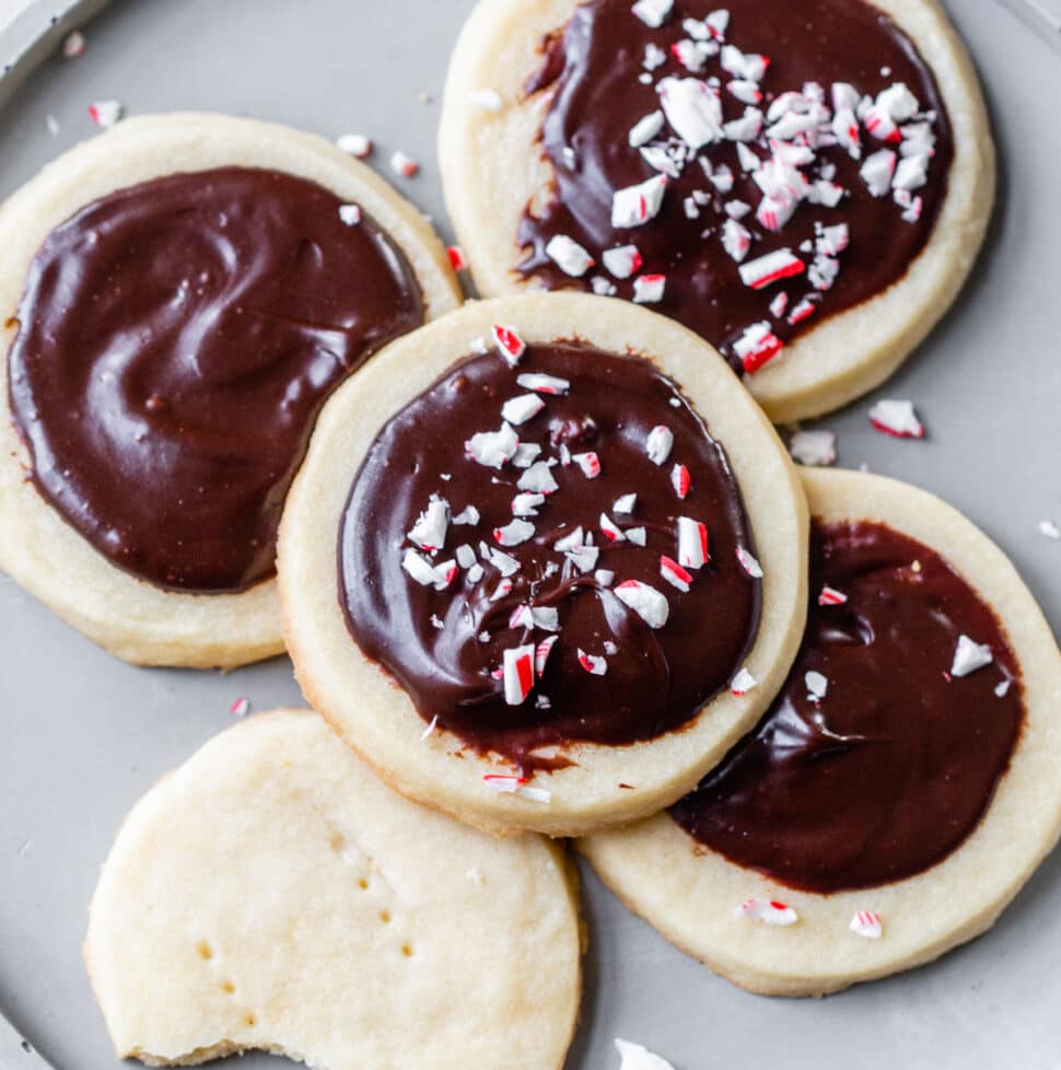 five shortbread cookies with chocolate icing on a gray plate