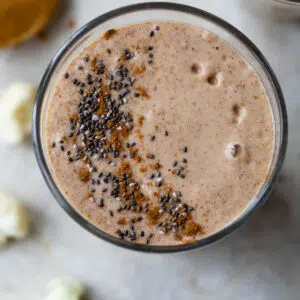 smoothie in a glass topped with cinnamon and chia seeds