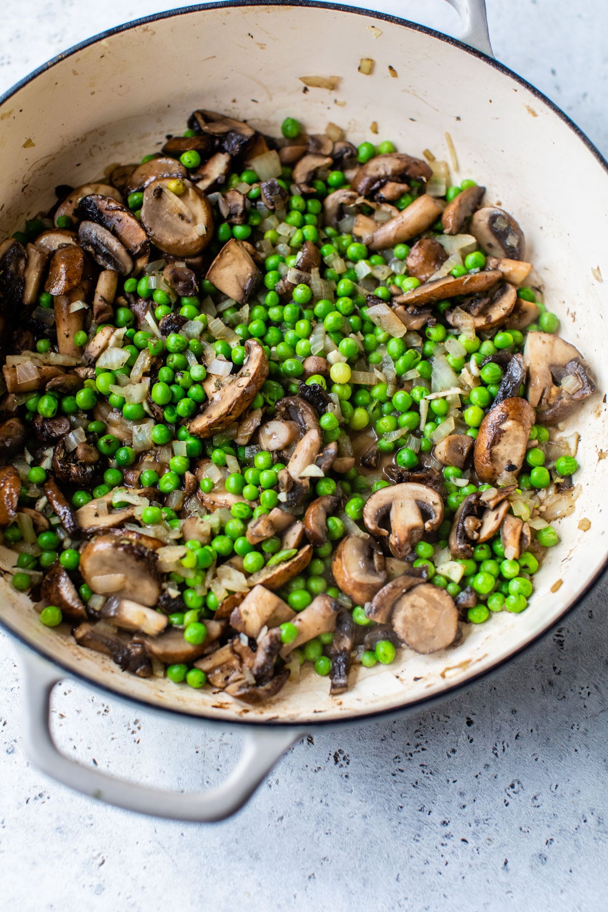 round dish with cooked mushrooms and peas