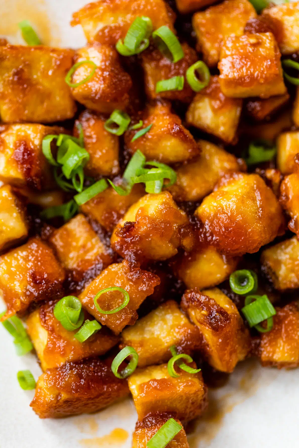 tofu coated in a honey sriracha sauce and sprinkled with green onions