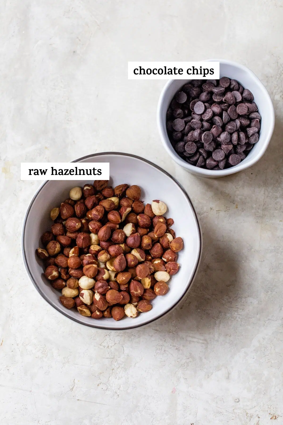 hazelnuts in a bowl and chocolate chips in a separate bowl