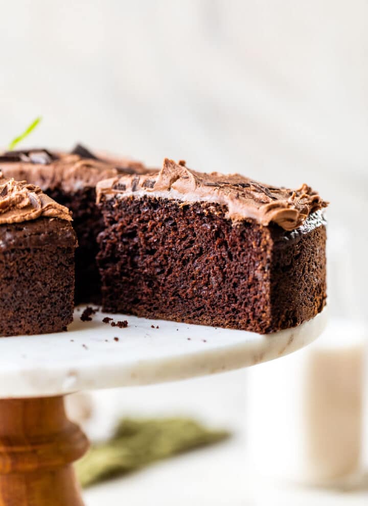 an entire chocolate cake topped with fresh mint and a slice cut out of it
