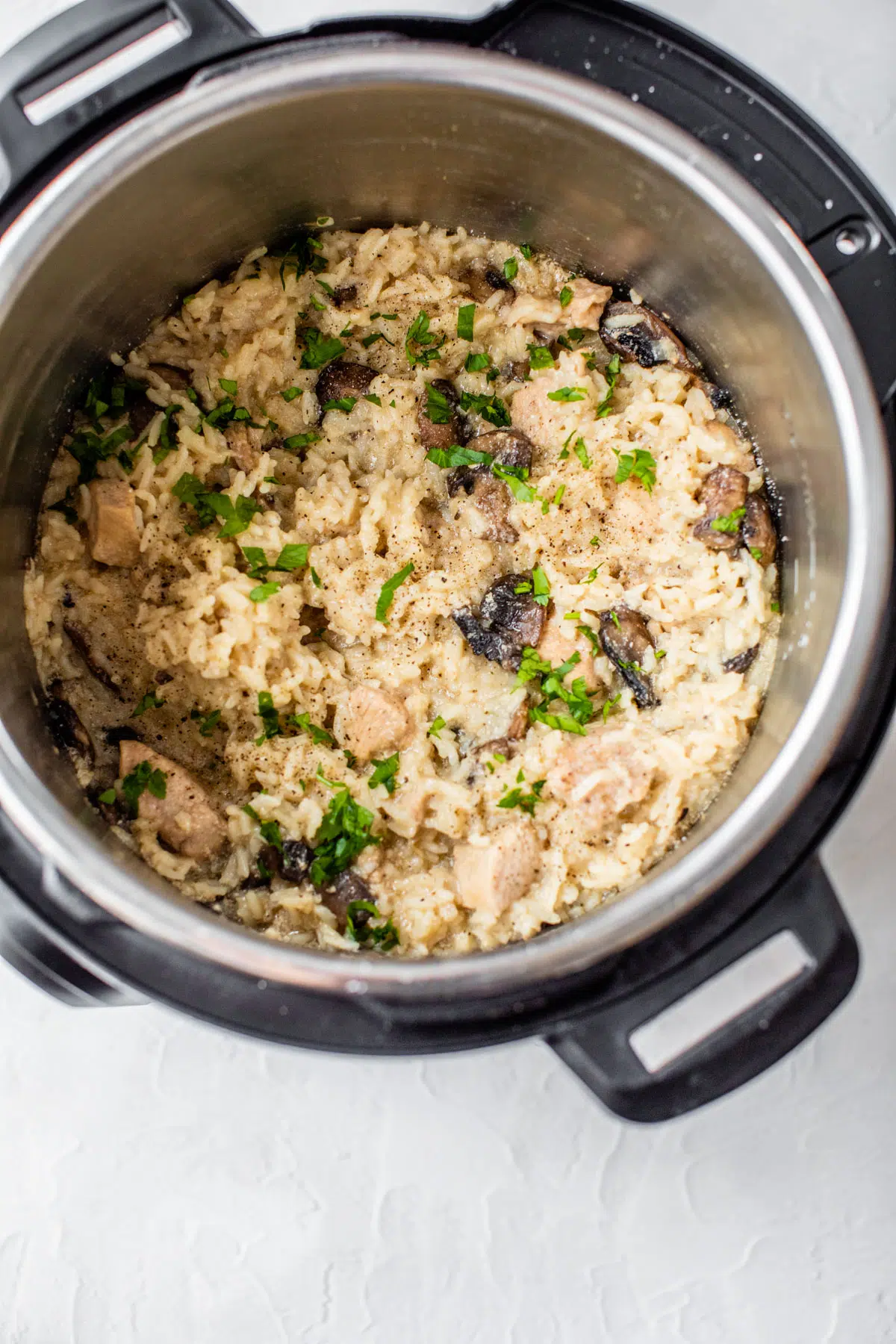 pressure cooker with cooked rice, mushrooms and chicken