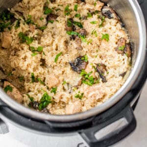 pressure cooker with rice, chicken, mushrooms, and fresh parsley