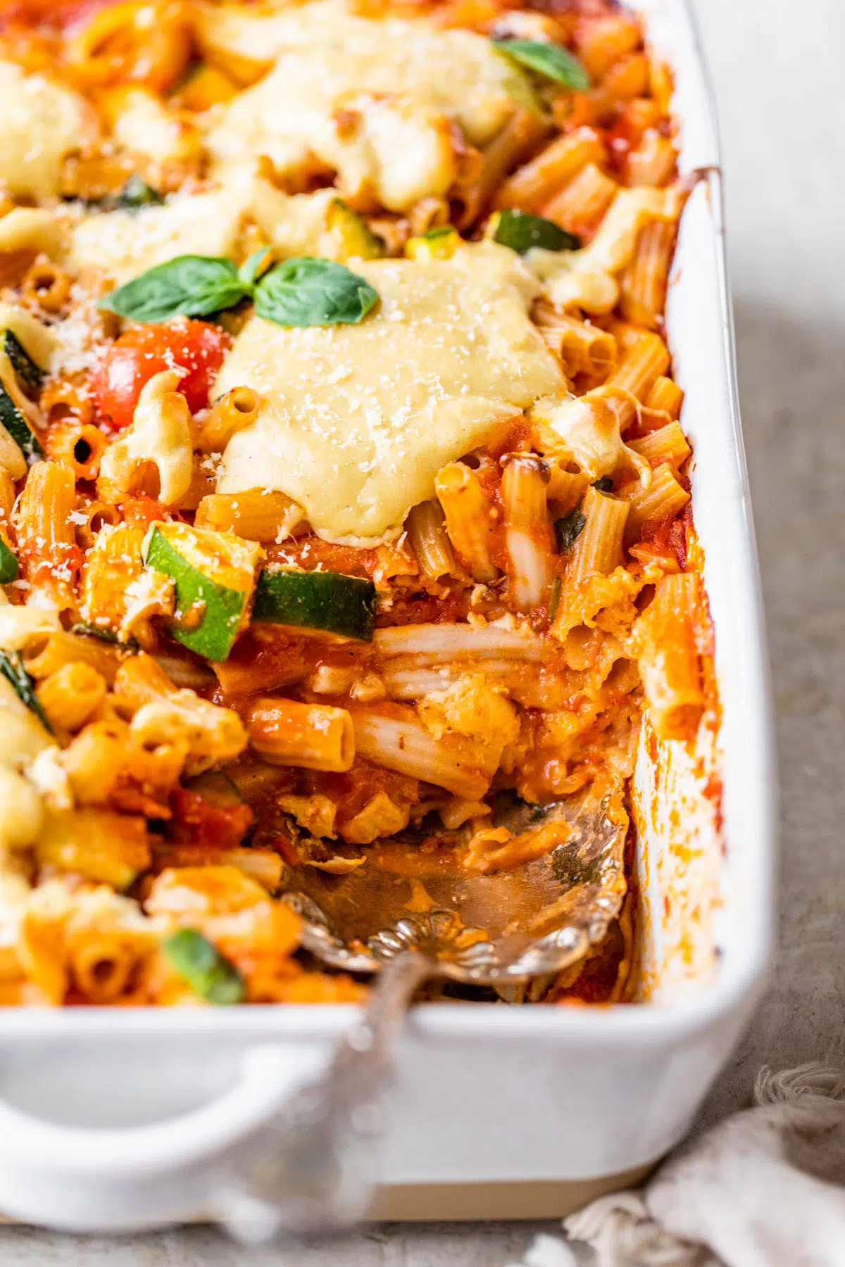 pasta bake in a casserole dish with a serving spoon