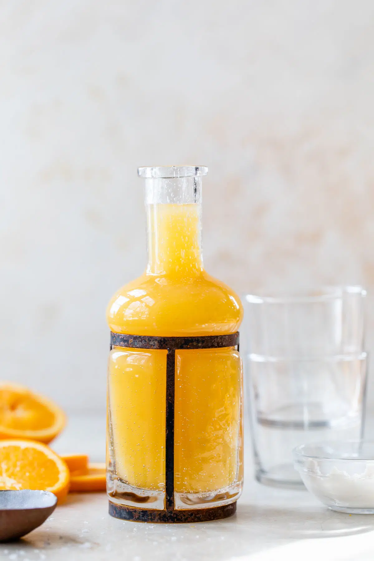 a tall glass jar filled with orange juice