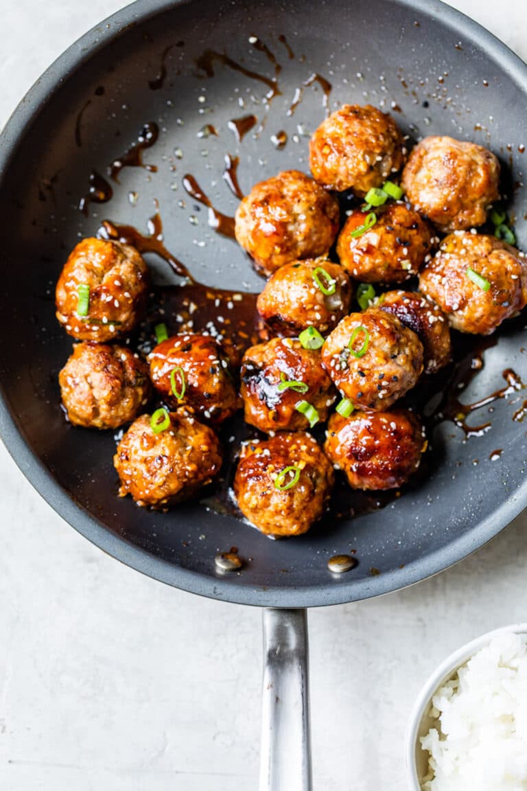cooked meatballs in a skillet with an asian sauce