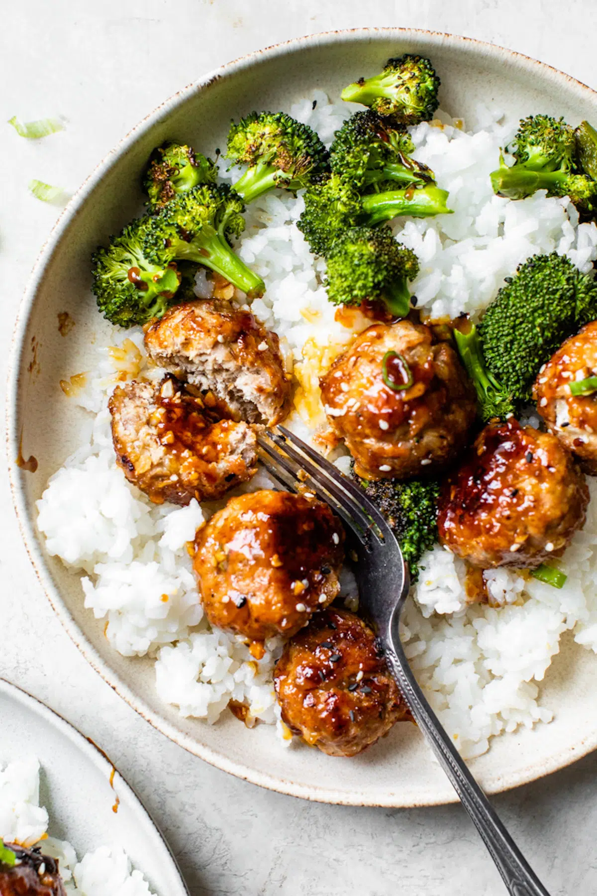 a bowl of white rice topped with broccoli and meatballs