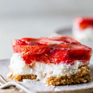 a piece of strawberry pretzel salad on a plate with a fork