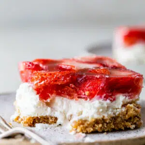 a piece of strawberry pretzel salad on a plate with a fork