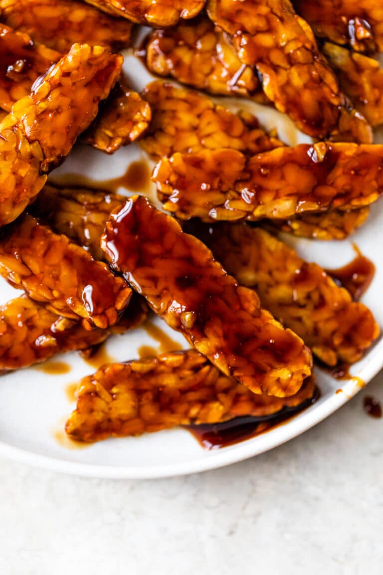 tempeh coated in an orange sauce on a plate