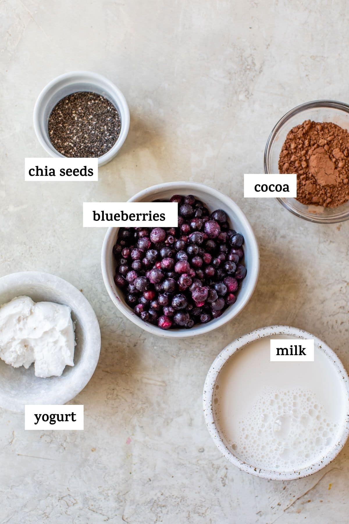 ingrédients nécessaires pour faire un smoothie, comme des bleuets congelés et de la poudre de cacao