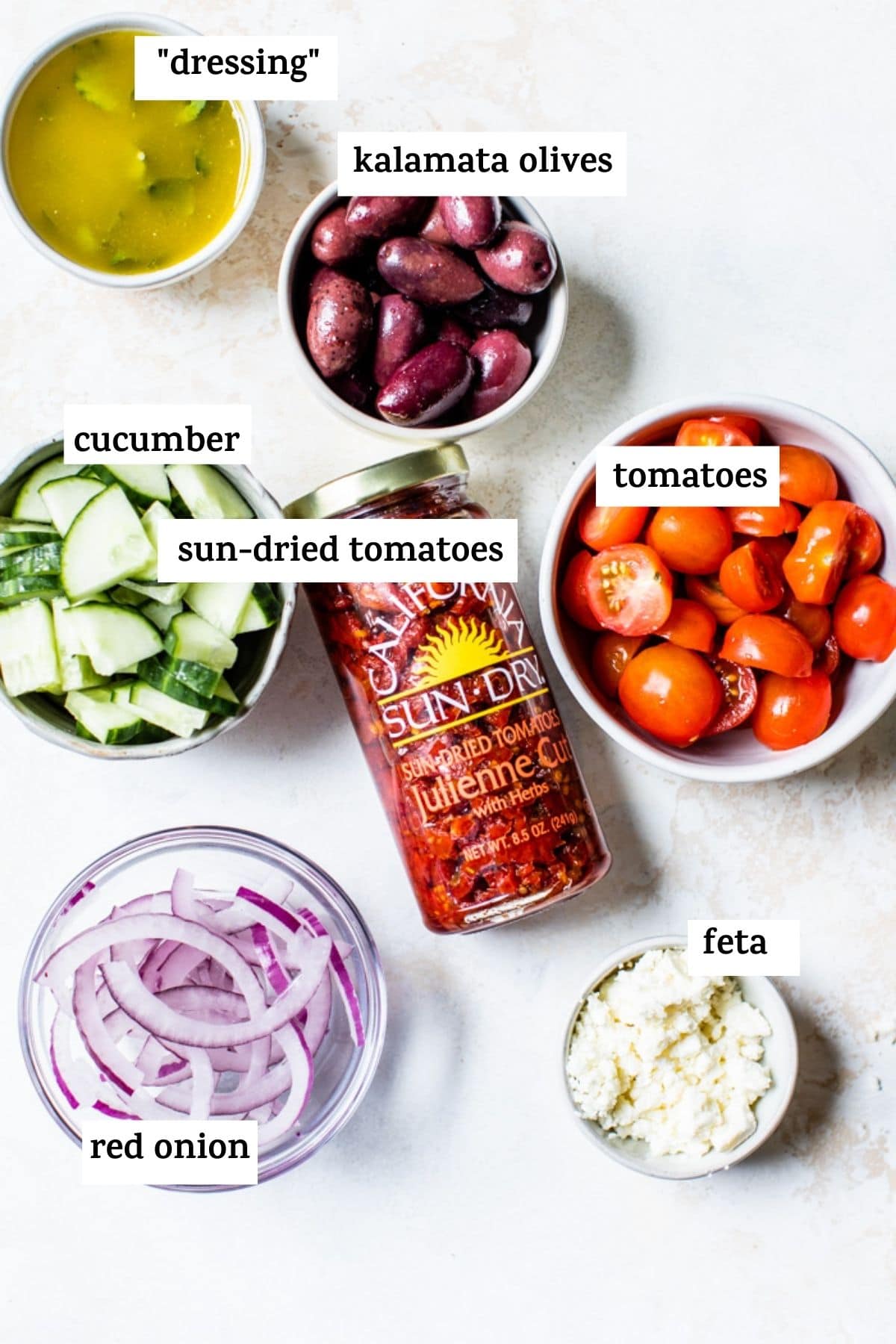 ingrédients de la salade de pâtes comme les tomates séchées au soleil et l'oignon rouge