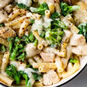 skillet filled with pasta, chicken, broccoli, and alfredo sauce