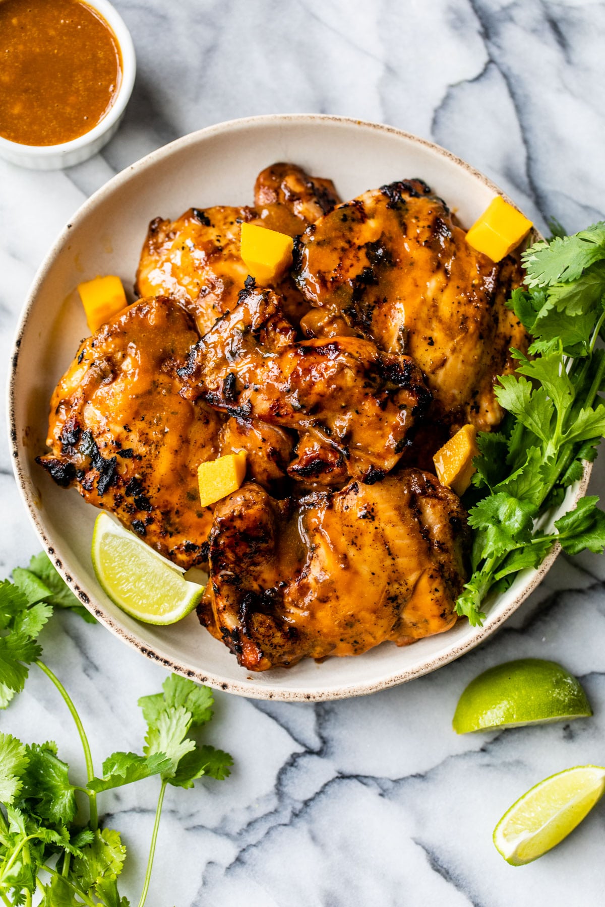 grilled chicken thighs coated in a mango marinade