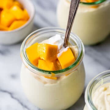 mango mousse in jars topped with diced mangos