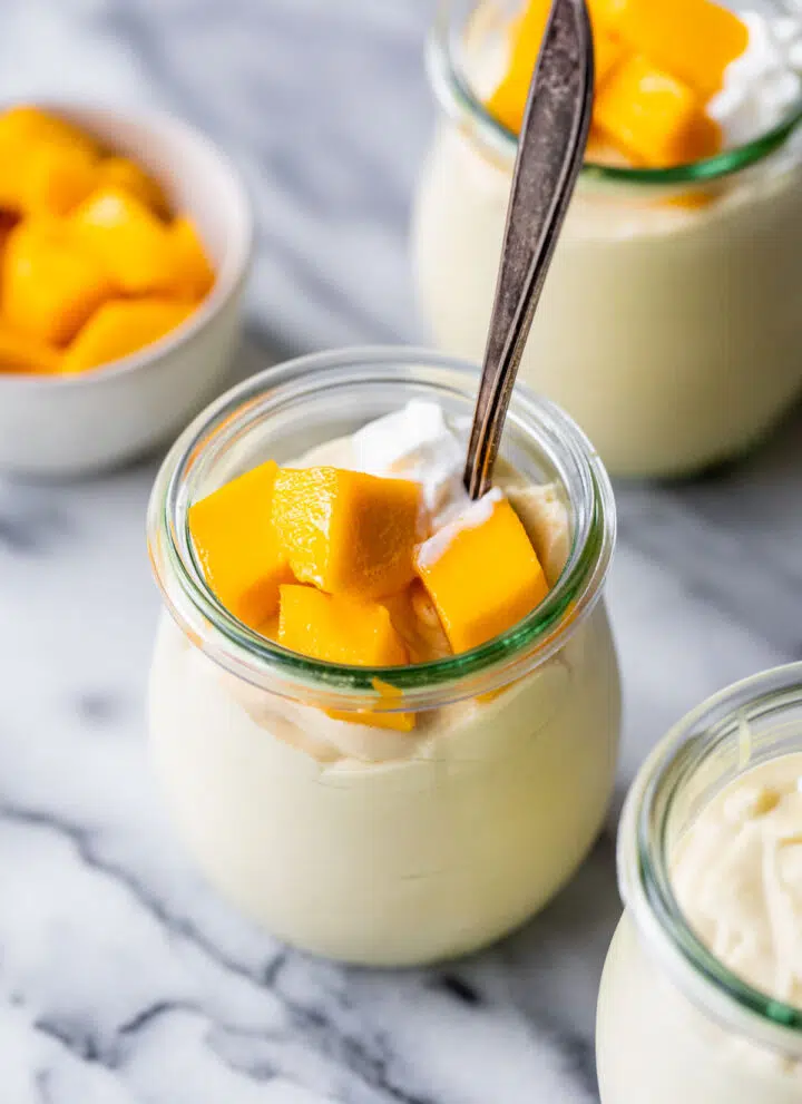 mango mousse in jars topped with diced mangos