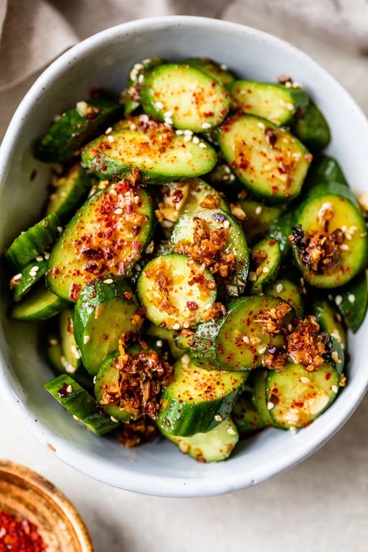 sliced cucumbers in a bowl topped with chili flakes