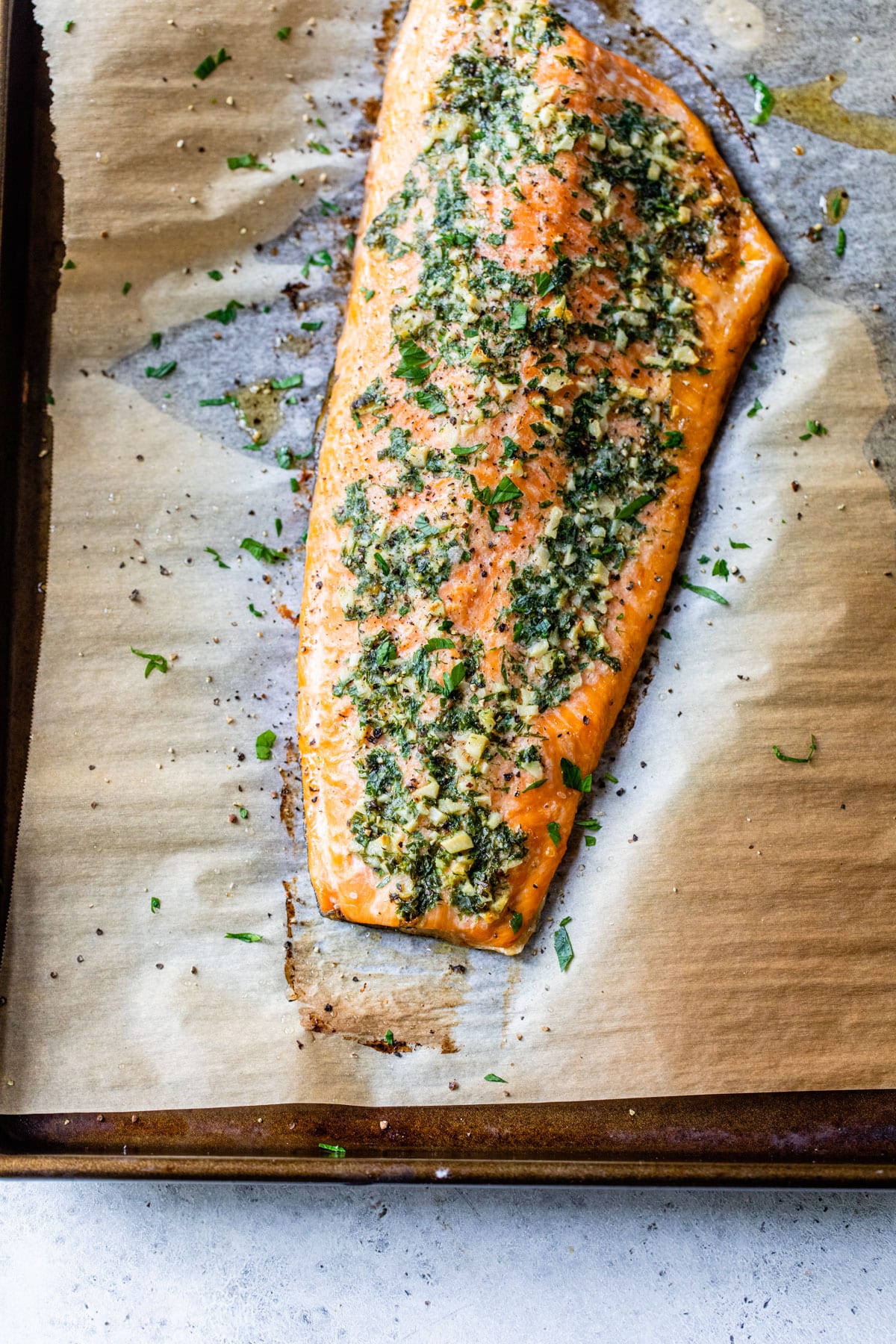 baked salmon fillet on parchment paper on a baking sheet