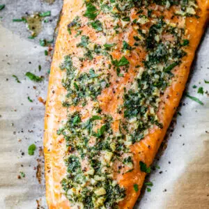baked salmon fillet with garlic and herbs on parchment paper