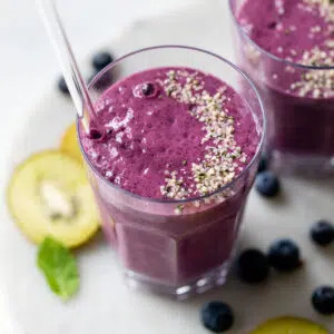 blueberry smoothie in a glass topped with hemp seeds