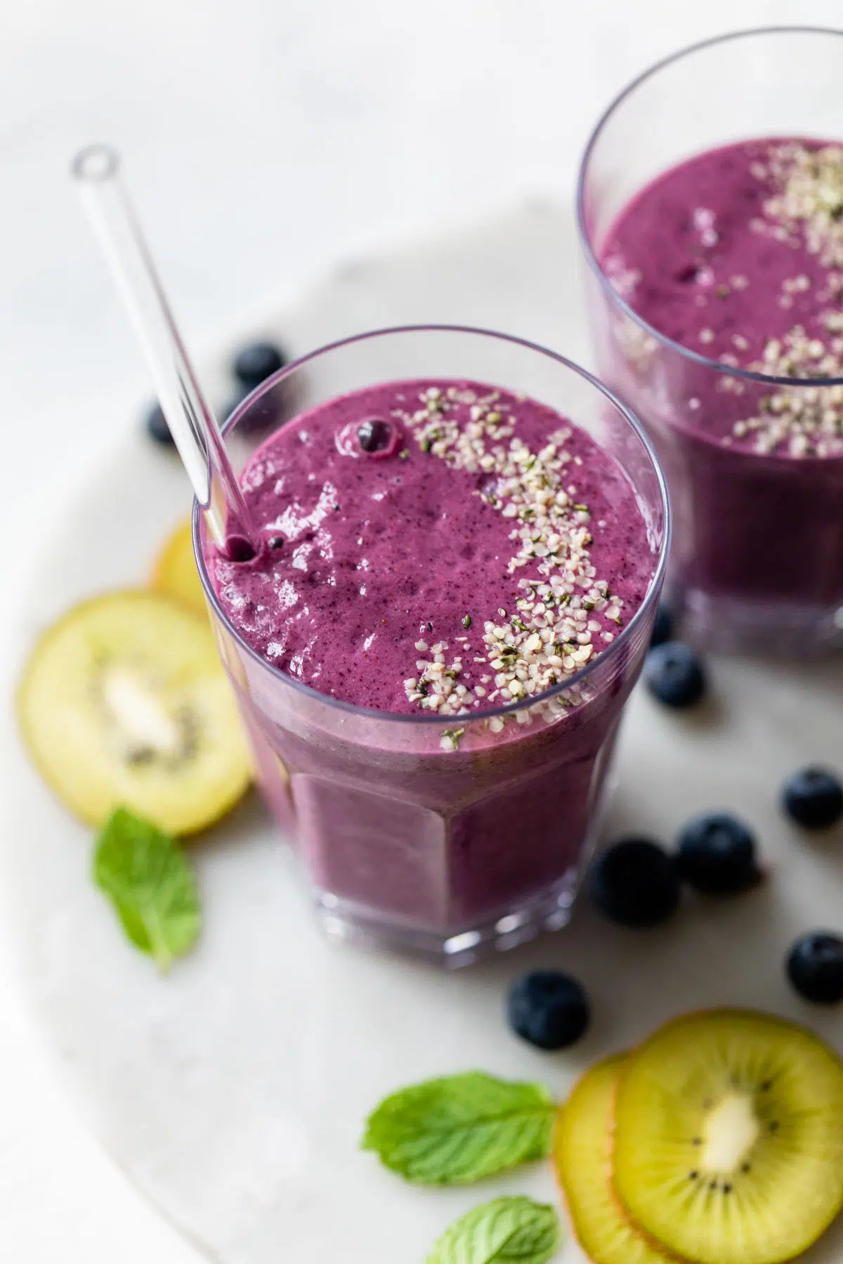 blueberry smoothie in a glass topped with hemp seeds